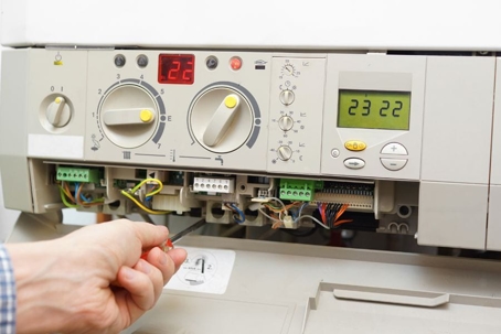 hvac technician inspecting furnace