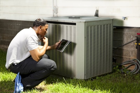 technician inspecting air conditioning unit